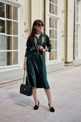 a lady in a green dress with a belt